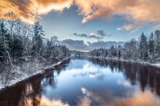 Gaujas upe sniegotā ziemas vakarā saulrieta laikā Siguldā, Latvijā